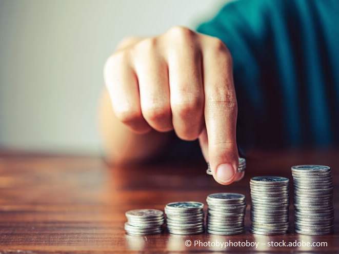 Pflegekosten und Pflegefinanzierung - Hand, die Geldmünze aufsteigend stapelt